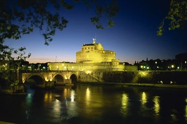 View across River Tiber to illuminated Castel Sant Angelo at dusk