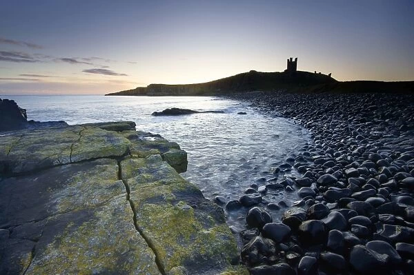 View across the Rumble Churn at dawn towards the ruins of Dunstanburgh Castle