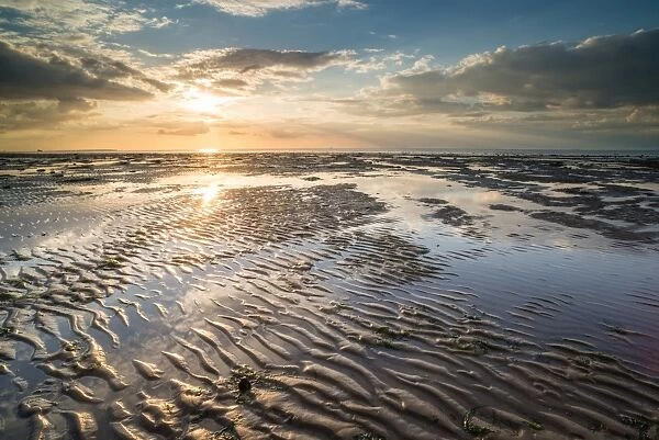 View of sandy beach and pools at low tide, at sunset, Reculver, Kent, England, United Kingdom
