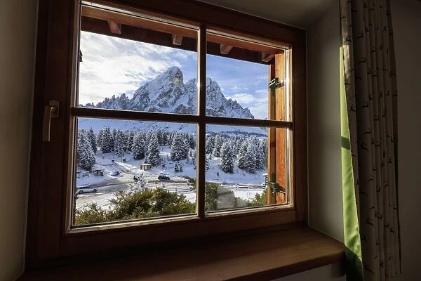 View of Sass De Putia surrounded by snowy woods from the window, Passo Delle Erbe
