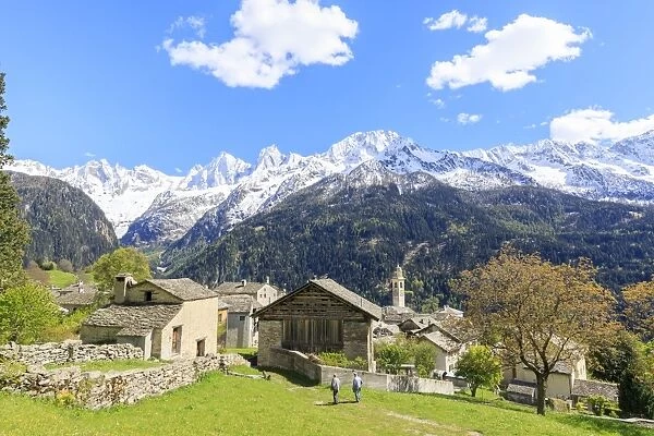 View of Soglio between meadows and snowy peaks in spring, Maloja, Bregaglia Valley