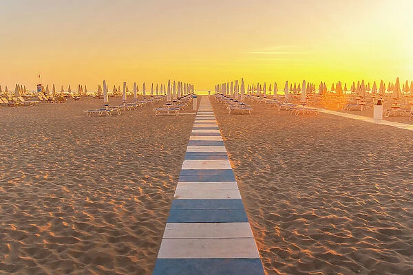 View of sunrise and sunshades on the Lido on Rimini Beach, Rimini, Emilia-Romagna, Italy, Europe