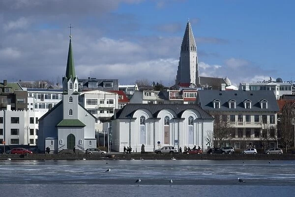 View over Tjornin (pond) to church and Cathedral, Reykjavik, Iceland, Polar Regions
