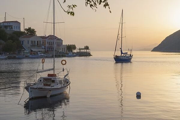 View across the tranquil harbour, sunrise, Gialos (Yialos), Symi (Simi), Rhodes, Dodecanese Islands