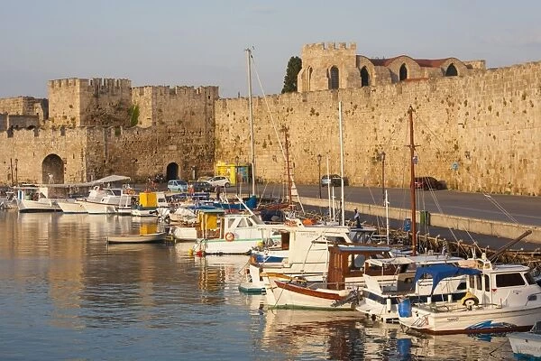 View across tranquil Kolona Harbour to the city walls, sunrise, Rhodes Town, Rhodes