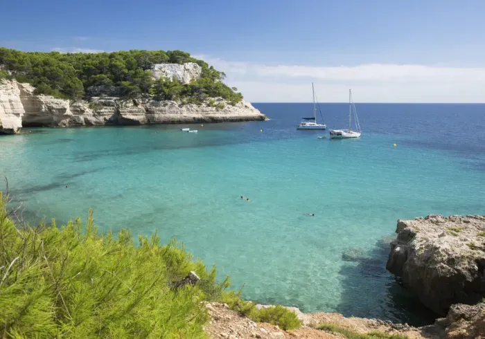 Framed Print : View over the turquoise waters of Cala Mitjana to pine-clad limestone cliffs