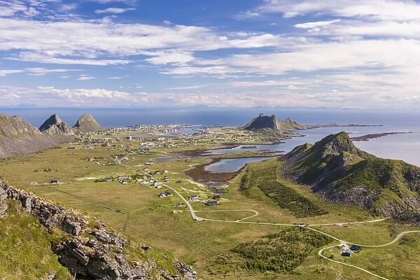 View of village of Sorland framed by green meadows and sea, Vaeroy Island, Nordland county