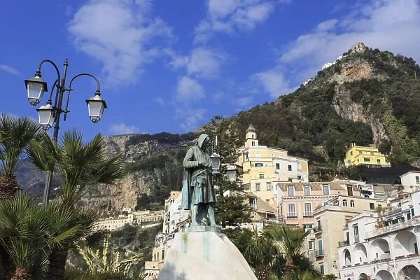 View from waterfront to statue, town of Amalfi and hillside, Costiera Amalfitana (Amalfi Coast)