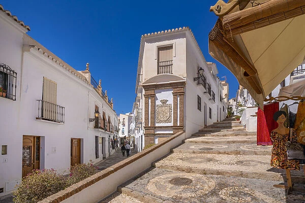 View of whitewashed houses and clothes shop on narrow street, Frigiliana, Malaga Province, Andalucia, Spain, Mediterranean, Europe