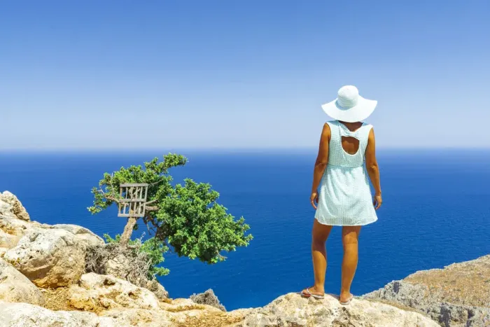 Framed Print : Back view of woman with fashion dress and hat looking at the sea from cliffs, Crete Framed Print : Back view of woman with fashion dress and hat looking at the sea from cliffs, Crete