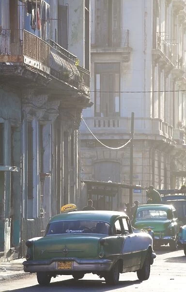 Vintage American car taxi on Avenue Colon during morning rush hour soon after sunrise, Havana Centro, Cuba, West Indies, Central America