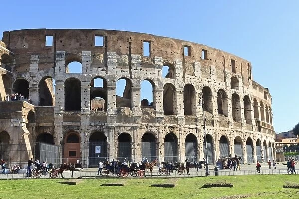 Visitors and horse carriages beside the outer wall of the Colosseum, Forum area, Rome, Lazio, Italy, Europe