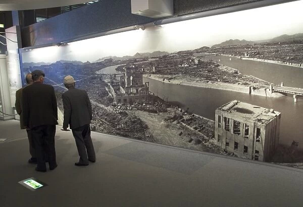Visitors looking at huge wall poster showing the destruction