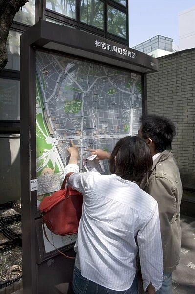 Visitors looking at a Tokyo city map in the Omotesando neighbourhood of Shibuya
