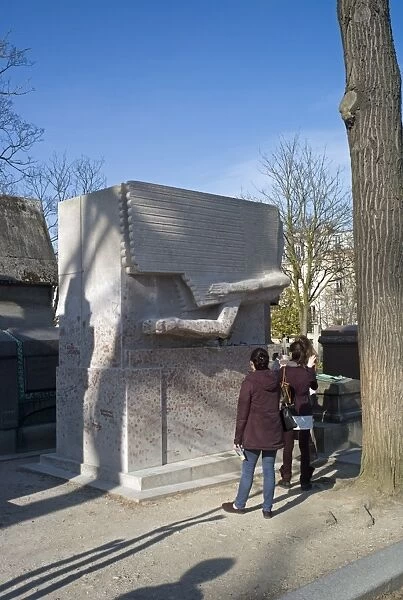 Visitors photograph the tomb of Oscar Wilde, Pere Lachaise cemetery, Paris