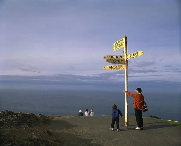 Visitors by the sign at Cape Reinga on the coast of Northland