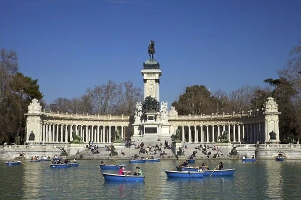 Visitors and tourists enjoy the boating lake in spring sunshine, Retiro Park