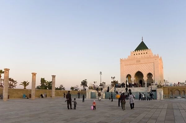 Visitors walk amongst the columns at The Unfinished Hassan Mosque, and the Mausoleum of Mohammed V