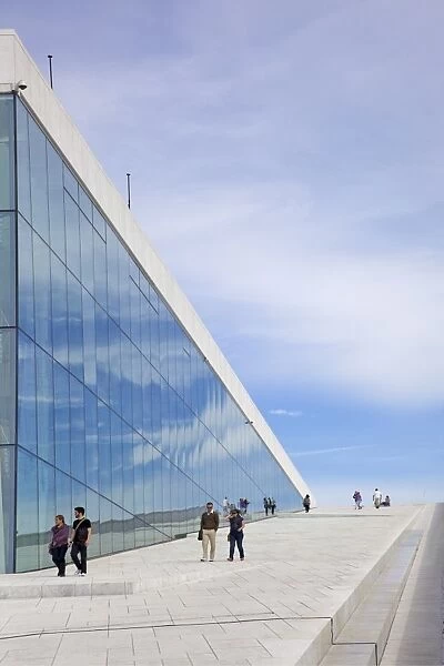 Visitors walking outside the Oslo Opera house exterior in summer sunshine