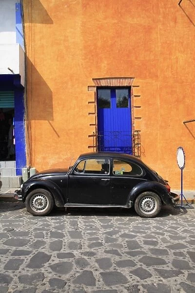 Volkswagen Beetle parked on cobblestone street, Tepoztlan, near Mexico City where many city dwellers spend weekends, Morelos, Mexico