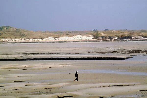 Walker on sands at low tide, Portbail, Cotentin Peninsula, Manche, Normandy