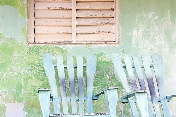 Detail of wall and rocking chair with faded paintwork in green and blue, a common sight in the small town of Vinales, Pinar Del Rio Province, Cuba, West Indies, Central America