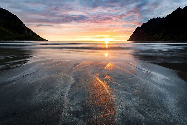 Warm lights of sunset reflecting on sand at Ersfjord beach, Senja island, Troms county