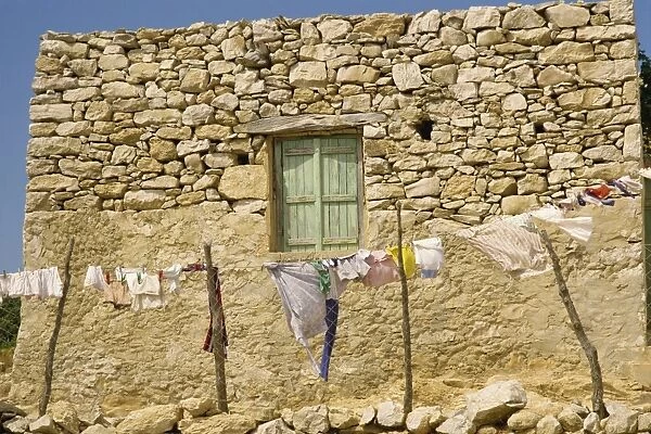 Washing line in front of an old stone wall with small