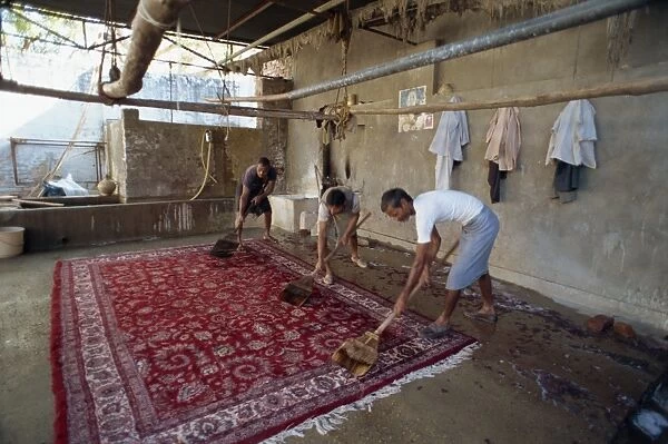 Washing newly made carpets to tighten pile and clean out dyes
