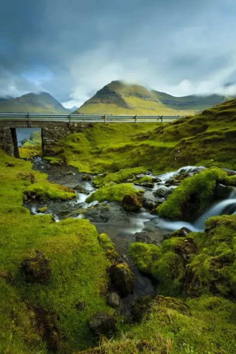 Framed Print : A waterfall cascading down the rocks towards the picturesque village of Funningur