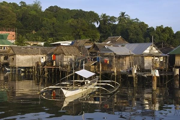 Waterfront stilt houses and catamaran fishing boat