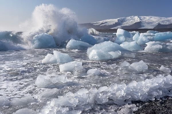 Wave splashing against broken icebergs, Breidamerkursandur black sands