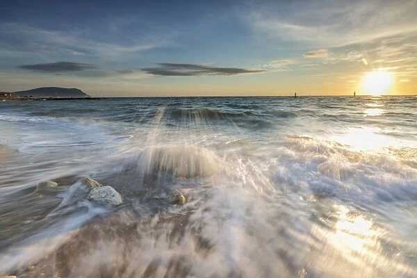 Waves crashing on the sandy beach framed by sunrise, Porto Recanati, Province of Macerata