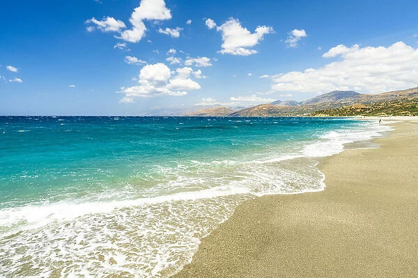 Waves of turquoise clear sea crashing on white sand of Triopetra beach, Plakias