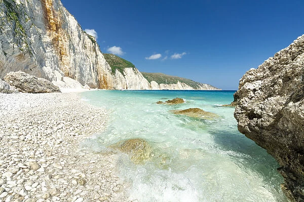 Waves of the turquoise clear sea washing the white stones of Fteri Beach, Kefalonia, Ionian Islands, Greek Islands, Greece, Europe