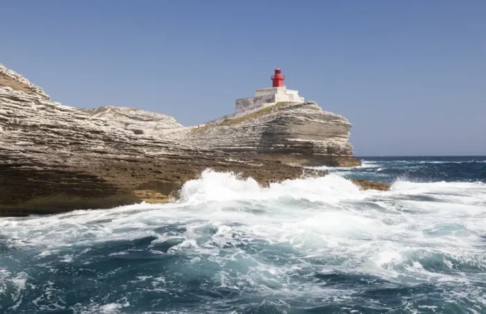 Framed Print : Waves of the turquoise sea crashing on the granite white cliffs and lighthouse, Lavezzi Islands