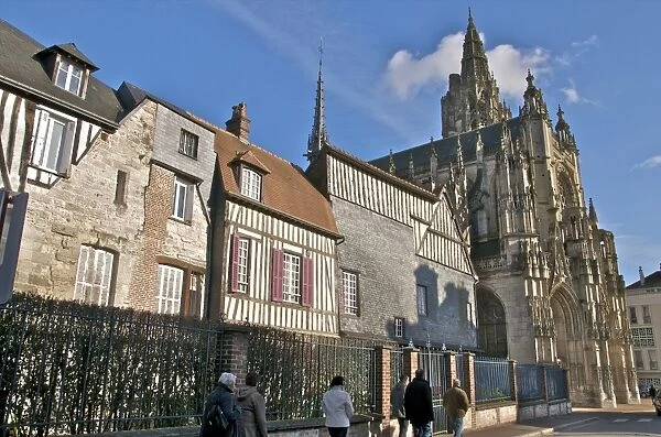 The west facade of the 15th century Notre Dame church, houses and tourists