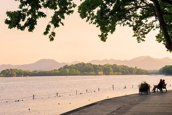 West Lake shore with hilly landscape and silhouettes, Hangzhou, Zhejiang, China, Asia