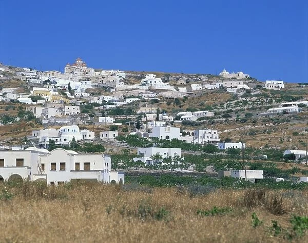 White buildings in village on a hillside with church on skyline