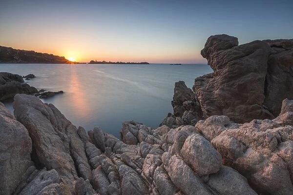 White cliffs and blue sea framed by the lights of sunset Santa Teresa di Gallura
