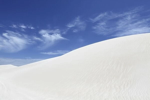 Wind blows white sand across the top on dune, under a blue sky, at Lancelin, Western Australia, Australia, Pacific