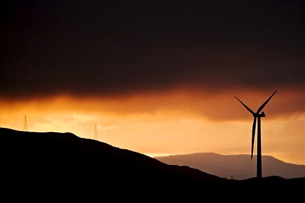 Windmill and power lines at dawn