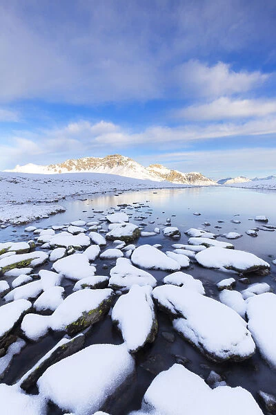 Winter scenery with frozen alpine lake, Stelvio Pass, Valtellina, Lombardy, Italy, Europe
