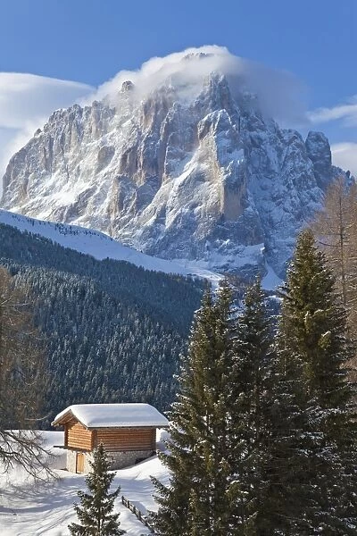 Winter snow covered mountain hut in front of Sassolungo mountain, 3181m