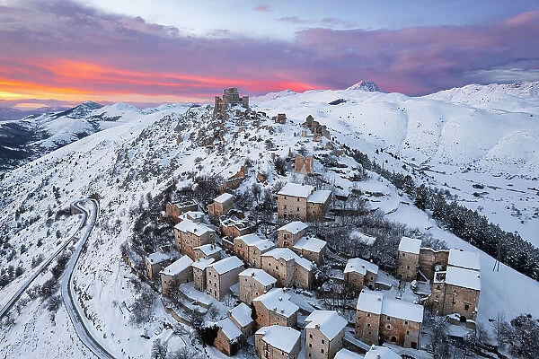 Winter view of the snowy medieval village of Rocca Calascio with the castle on top of the hill at dusk, Rocca Calascio, Gran Sasso e Monti della Laga National Park, Campo Imperatore, L'Aquila province, Abruzzo region, Italy, Europe