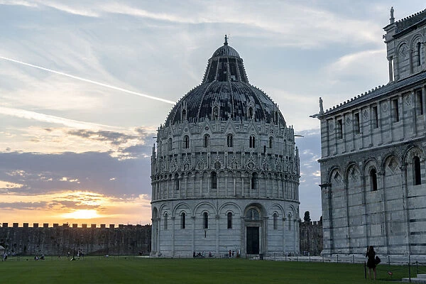 Woman admiring the majestic Pisa Cathedral (Duomo) and Baptistery at sunset