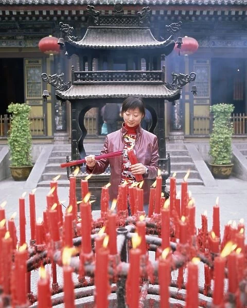 Woman with candle and incense offerings, Big Goose Pagoda temple, Xian