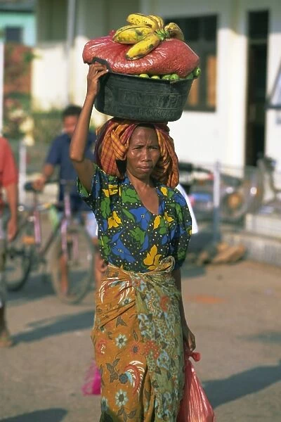 Woman carrying basket of fruit on her head