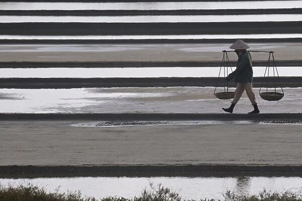Woman carrying salt on salt workings, Vietnam, Indochina, Southeast Asia, Asia