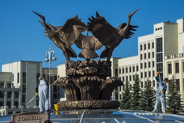 Woman cleaning a giant bird statue on top of a glass cupola on Nezalezhnasti Independence square, Minsk, Belarus, Europe